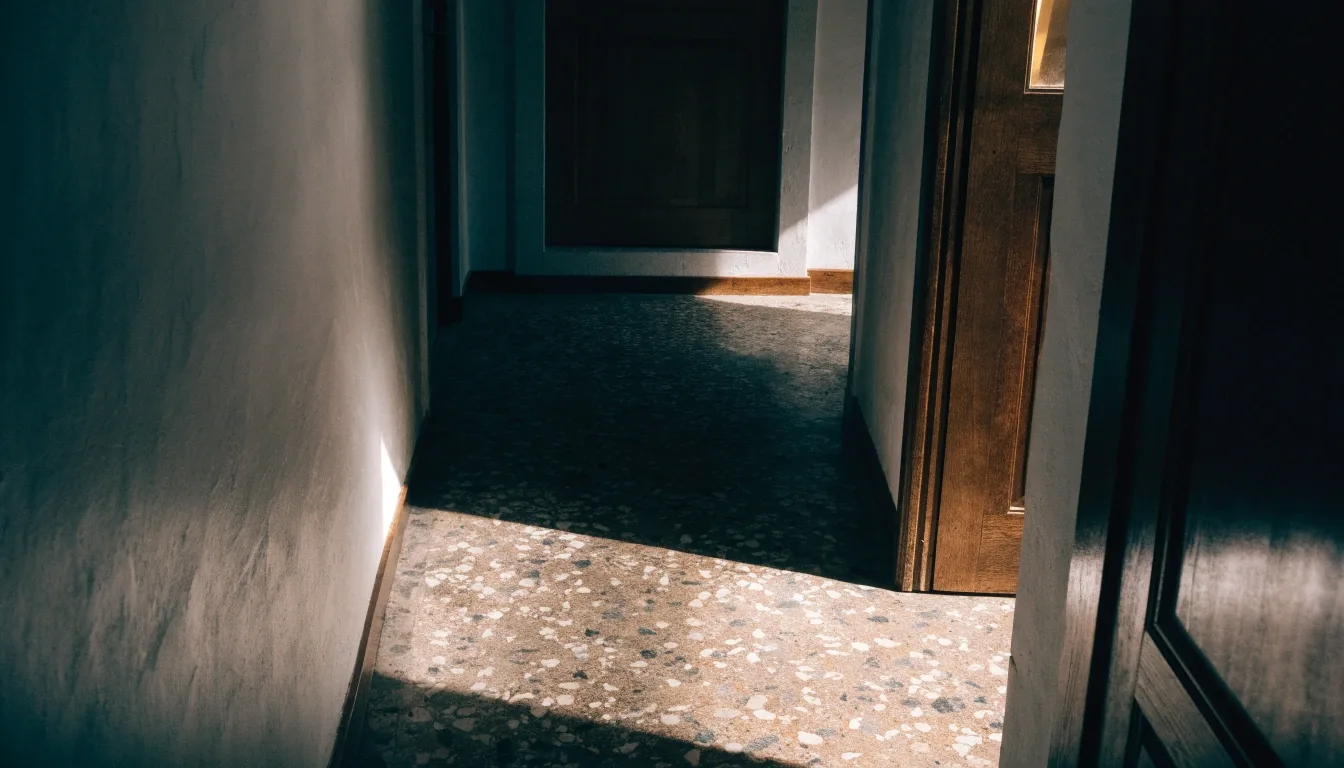 Pasillo de una vivienda española con luz de mediodía sobre el suelo